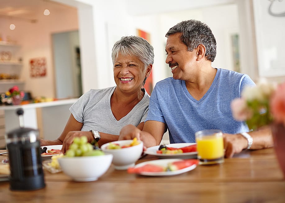 A retired senior couple happily having breakfast at home. — PeopleImages // Shutterstock