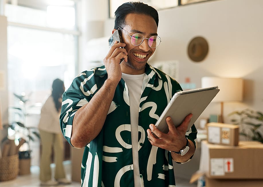 A man on the phone and looking at a tablet for an order. — PeopleImages // Shutterstock