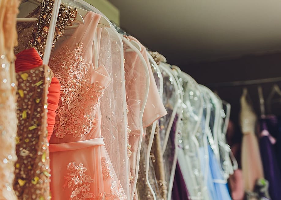 A row of ladies' long gown dresses in a closet. — Vershinin89 // Shutterstock