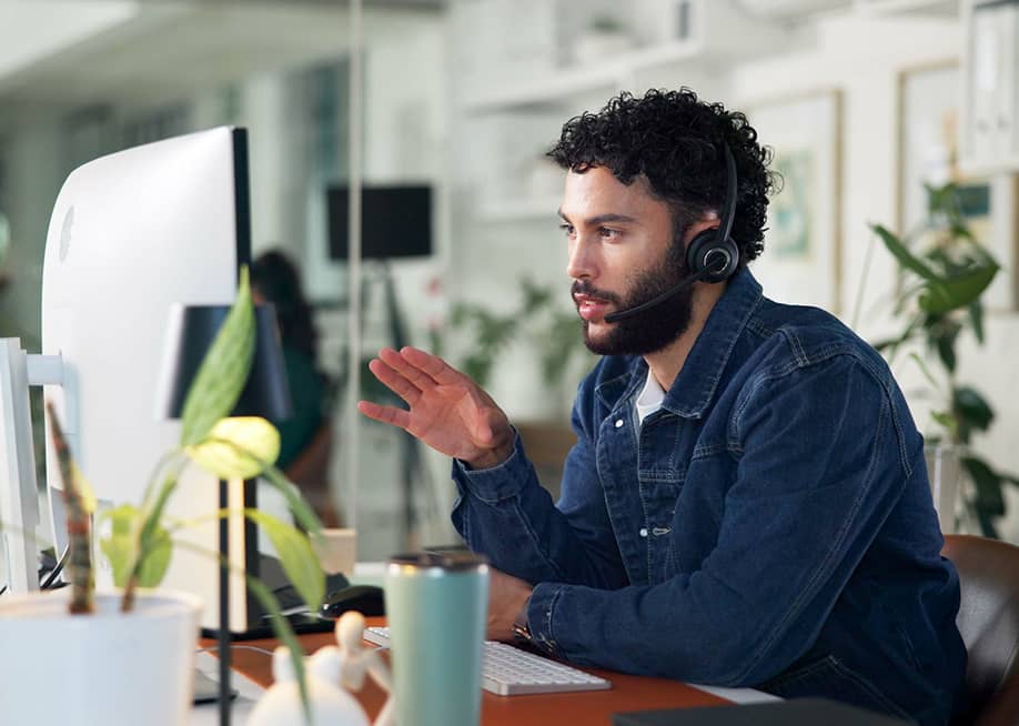 A male customer service representative on call with a client. — PeopleImages // Shutterstock