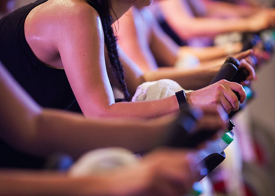Close up on the intense sweat in the arms of bike spin class students. — SophieMPhoto6 // Shutterstock