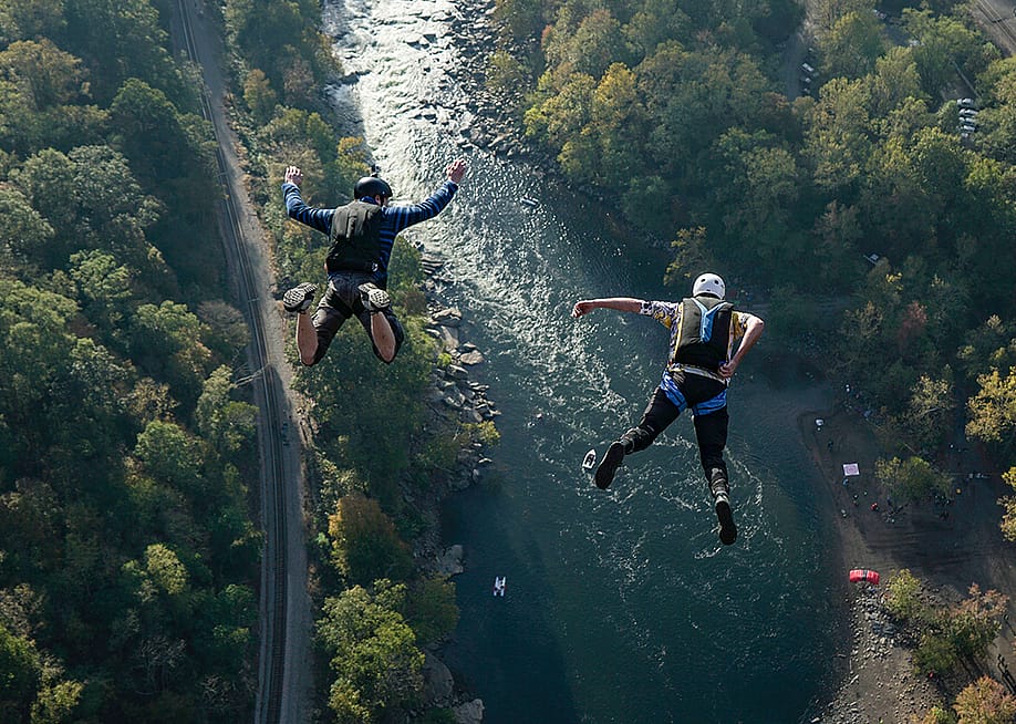 Two jumpers leap from New River Gorge Bridge in West Virginia. — Flying Pig Studios // Shutterstock