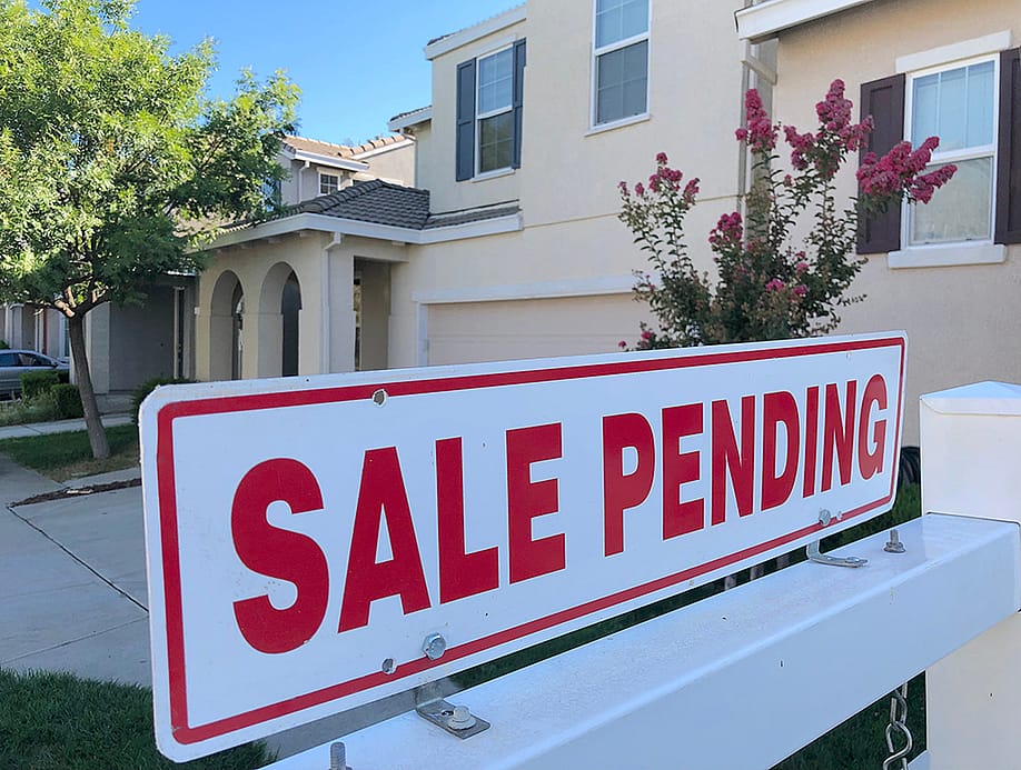 A sale pending sign in front of a house. — ZikG // Shutterstock