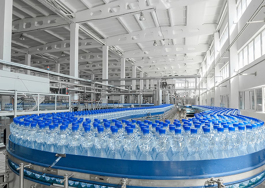 Massive production of plastic bottles on factory's conveyor belt. — Alba_alioth // Shutterstock