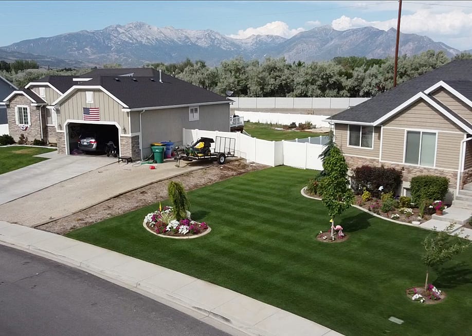 Aerial view of Jimmy Lewis’s golf course-like lawn in Utah, with striping patterns in green grass and three small trees in yard. — Jimmy Lewis