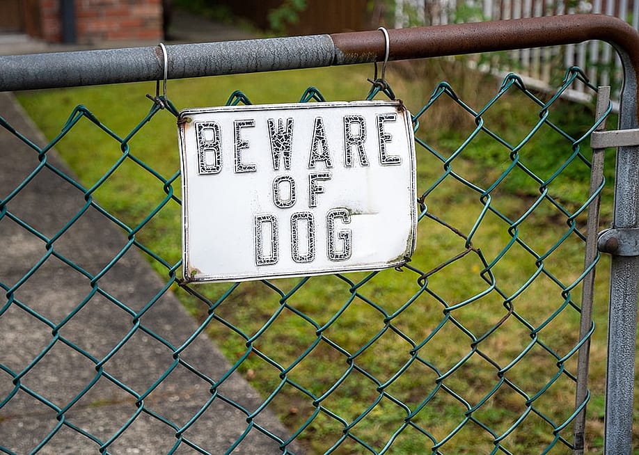 A Beware of Dog sign hung to a house's gate. — vietanh85 // Shutterstock