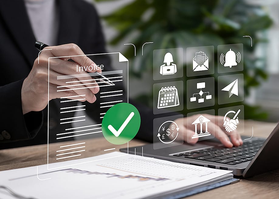 Automated invoice software graphics over a businessperson using a laptop. — Nichcha // Shutterstock