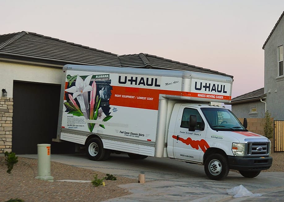 A U-Haul moving van parked in front of a newly built home. — Around the World Photos // Shutterstock