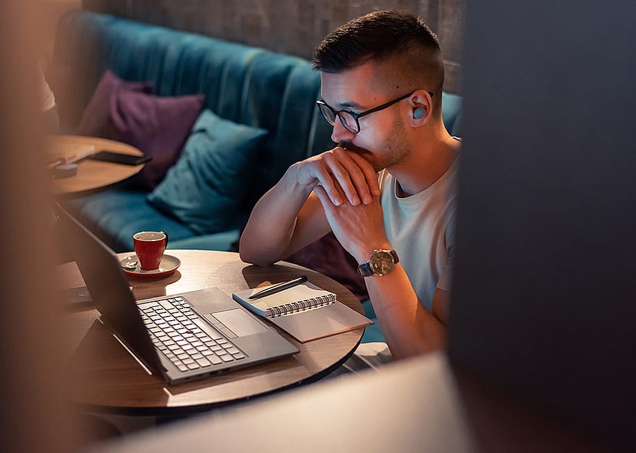 A focused male professional working from a cafe. — MalikNalik // Shutterstock