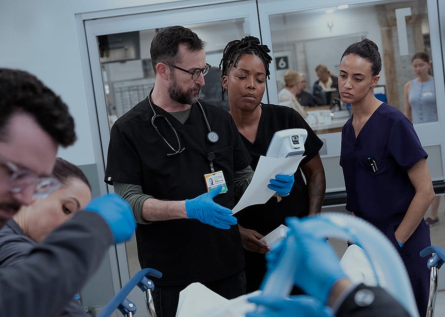 Noah Wyle, Ayesha Harris, and Alexandra Metz in a promotional still for season two, episode 13 of The Pitt. — Warrick Page // Warner Bros. Discovery