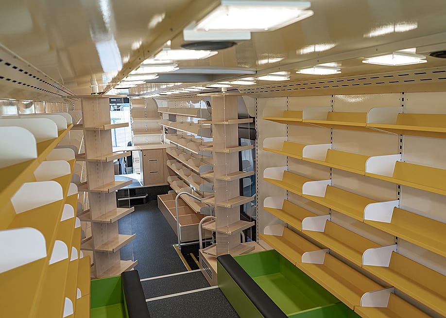 Interior of a modern bus converted into a small library. — dexdexfu // Shutterstock
