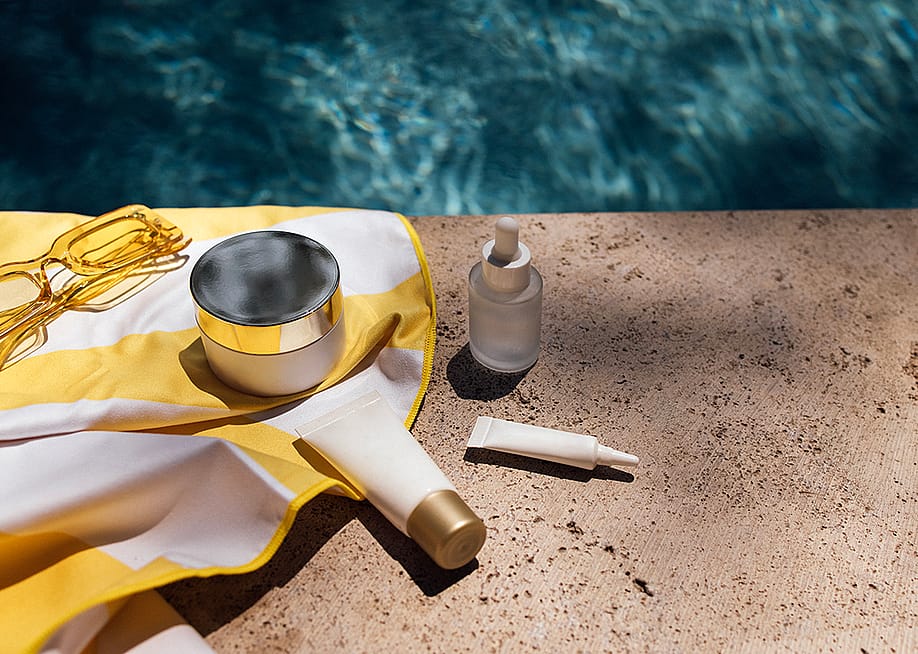 Skincare items in a towel next to a swimming pool. — Dasha Petrenko // Shutterstock