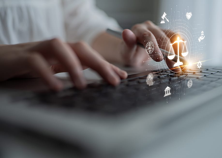 A person using a laptop that shows a futuristic justice scale with digital law interface. — Summit Art Creations // Shutterstock