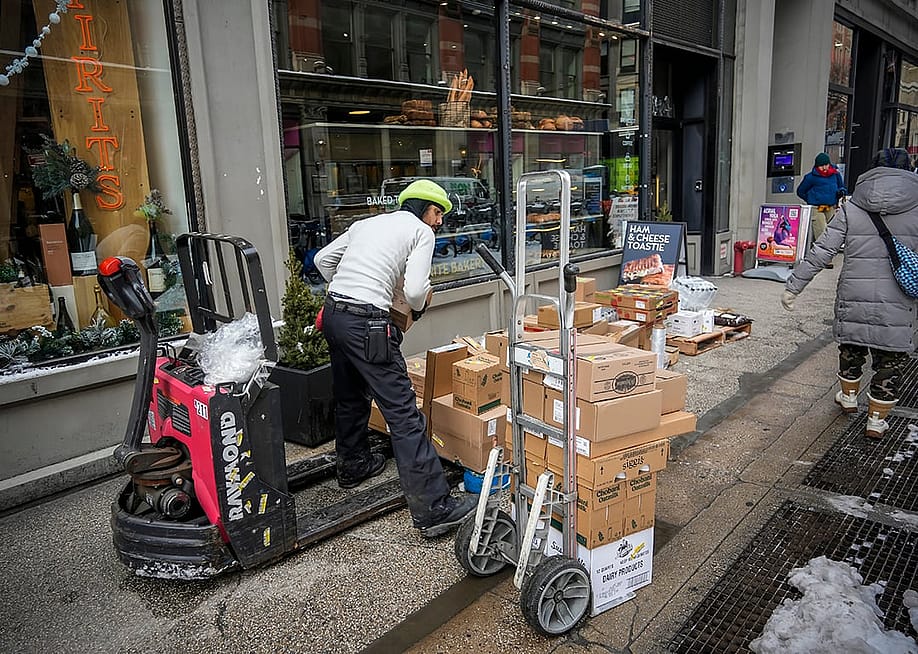 Delivery staff arrange provisions to a bakery in New York City. — rblfmr // Shutterstock