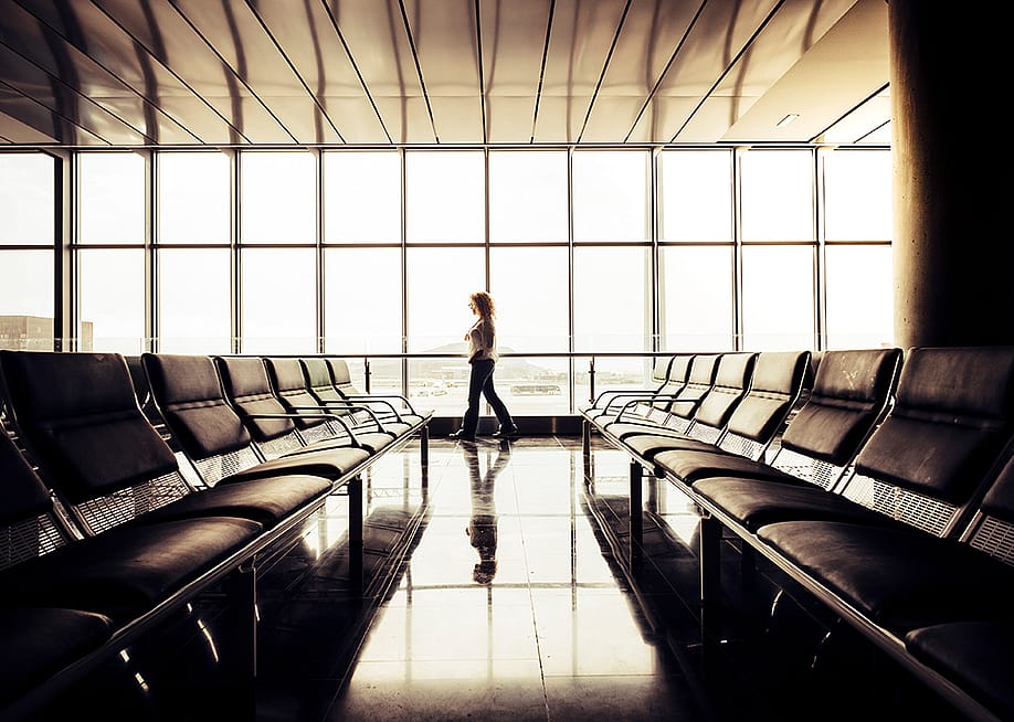 Woman waiting by the departure gate area in an airport. — simona pilolla 2 // Shutterstock