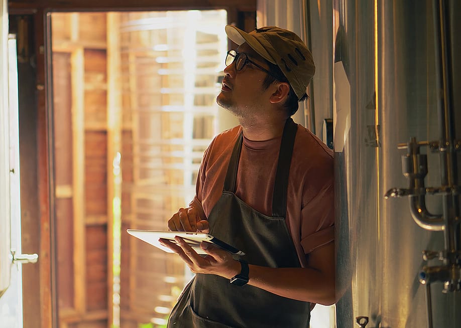 A male business owner checking craft brewery factory systems. — stock_bird // Shutterstock