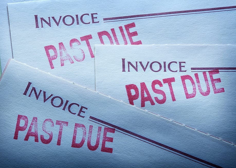Invoice statements with past due markings indicating overdue payments. — DNY 59 // Shutterstock