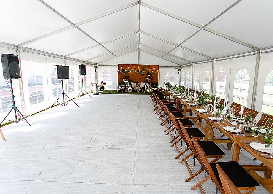 An events tent set up with a long table for a festival. — denisartist // Shutterstock