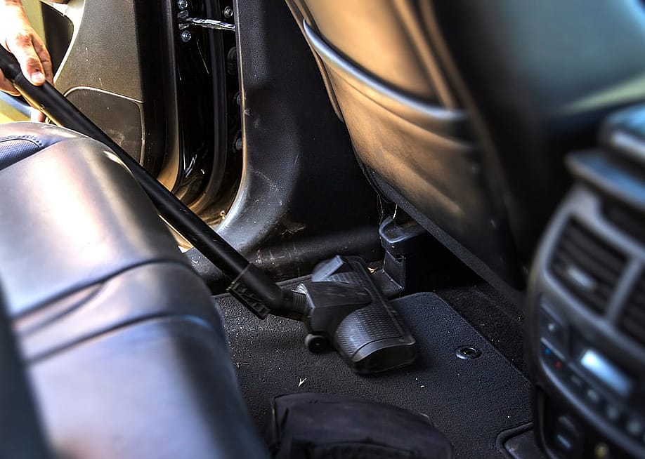 A vacuum cleans the interior of a car. — Natali-Natali love // Shutterstock