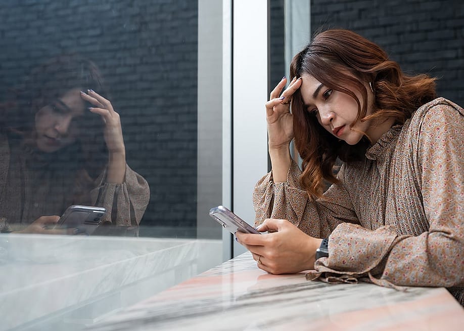 A person checking on her phone, while looking worried about something. — BaLL LunLa // Shutterstock