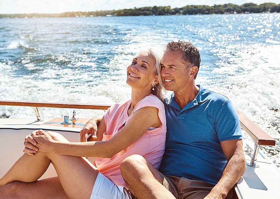 A couple enjoying their vacation time in a yacht trip. — PeopleImages // Shutterstock