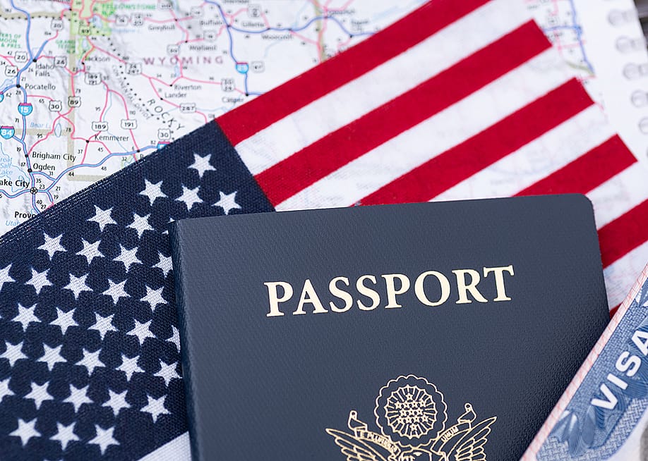 A U.S. passport on top of a U.S. flag and travel map. — Kosoff // Shutterstock