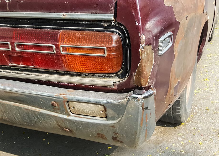 A close-up shot of the back of an old rusty car. — Wuttisit Somtui // Shutterstock