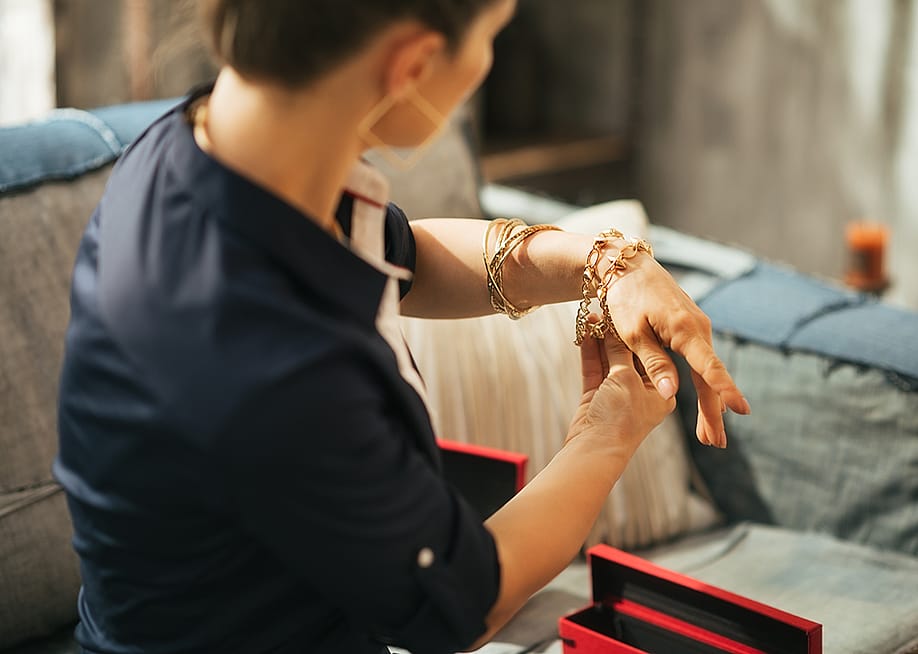 Woman at home trying on jewelry. — Alliance Images // Shutterstock