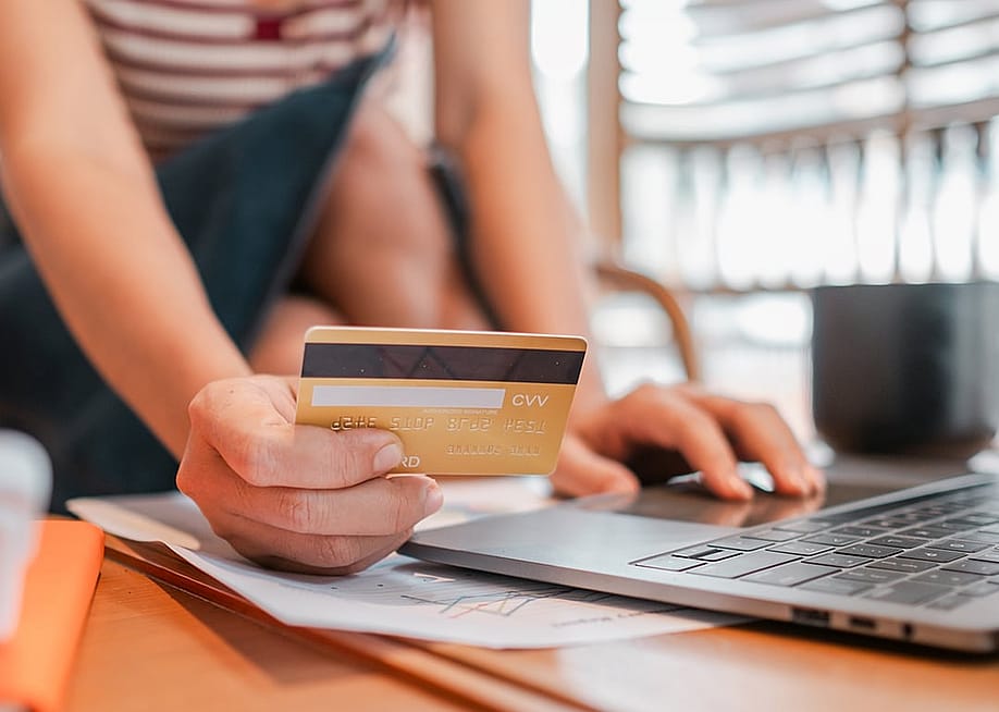 Person holding a credit card to purchase online. — Mongta Studio // Shutterstock