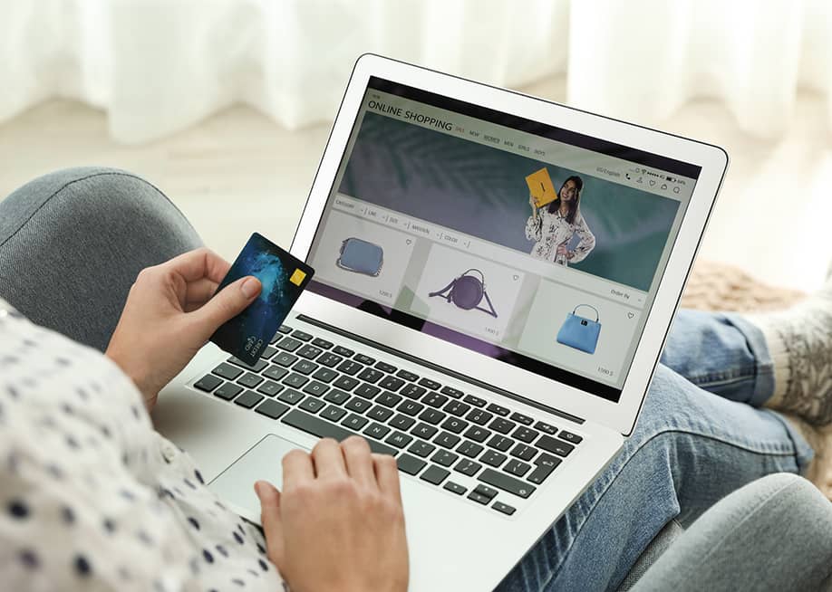 A person using a credit card as payment method for online shopping. — New Africa // Shutterstock