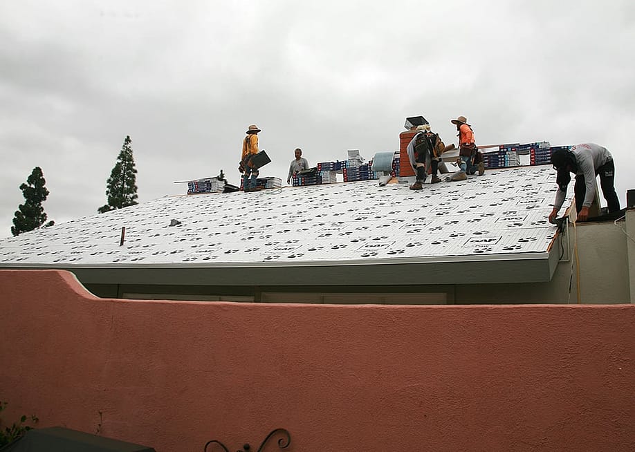 A construction team replacing a home's roof. — mikeledray // Shutterstock