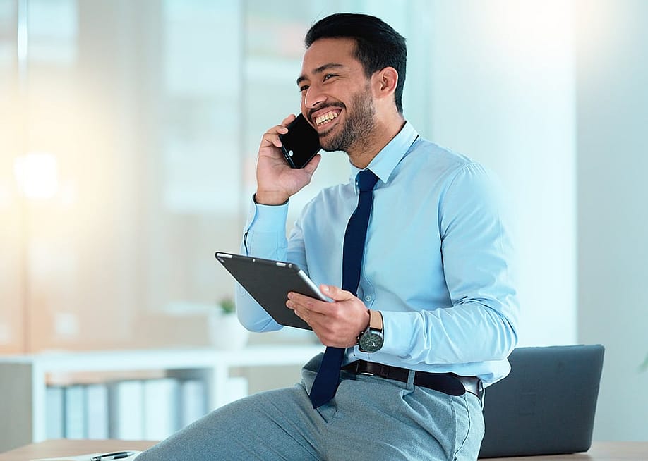 A happy businessman talking on the phone with a client. — PeopleImages // Shutterstock