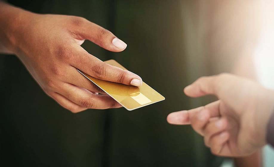 Person handing out a credit card. — PeopleImages // Shutterstock