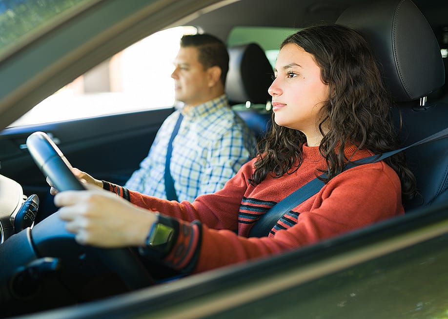 A teenage girl learning how to drive with her father. — antoniodiaz // Shutterstock