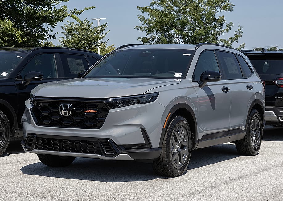A gray Honda CR-V Hybrid AWD TrailSport compact SUV displayed at a dealership. — Jonathan Weiss // Shutterstock