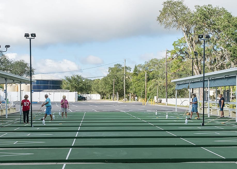 Older people playing shuffleboard at a resort. — Heidi Besen // Shutterstock