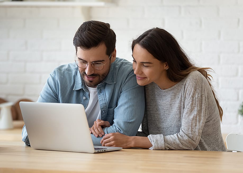 A married couple checking online accounts together in a laptop. — fizkes // Shutterstock