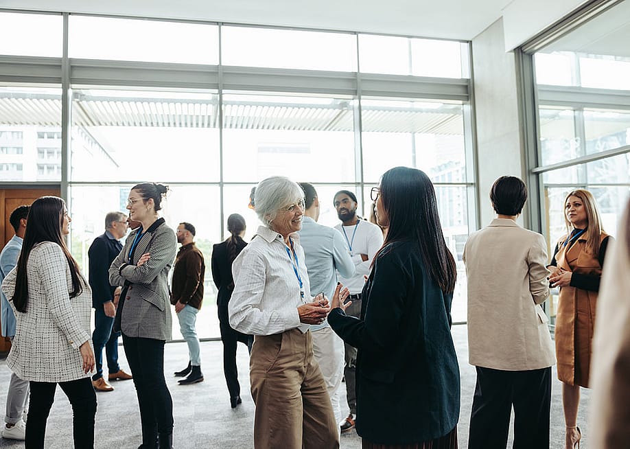 A diverse group of professionals networking at an event. — Jacob Lund // Shutterstock