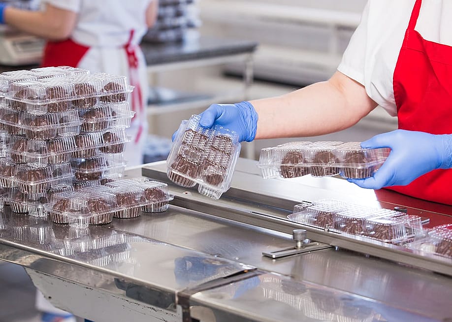 A production worker checking cake balls and confectionary products in an enterprise. — Norenko Andrey // Shutterstock