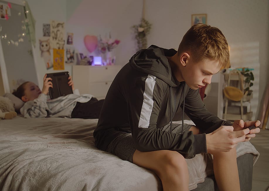 Teenage siblings at home scrolling through their phones. — Frame Stock Footage // Shutterstock
