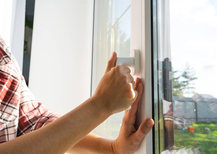 A person opening a glass home window in the morning. — Simol1407 // Shutterstock