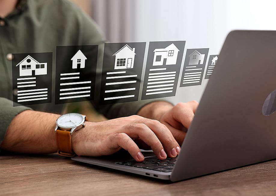 A person choosing residential home options from a laptop at home. — New Africa // Shutterstock