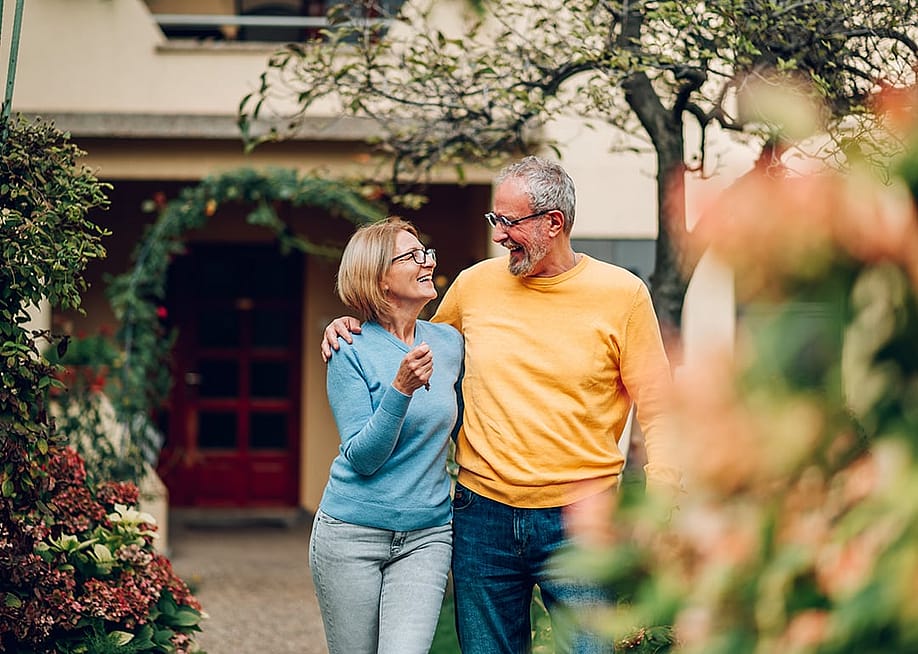 A senior couple happily standing in front of their new home. — Zamrznuti tonovi // Shutterstock