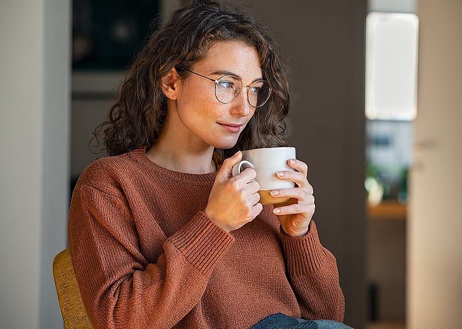 A person drinking coffee while relaxing at home. — Ground Picture // Shutterstock