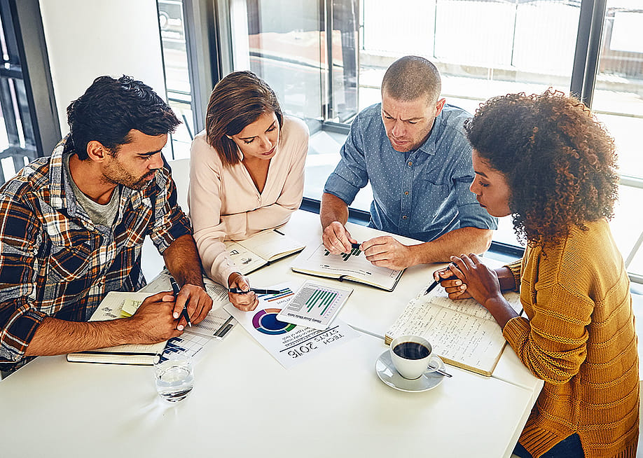 A team of designers engaged in a meeting in an office. — PeopleImages // Shutterstock