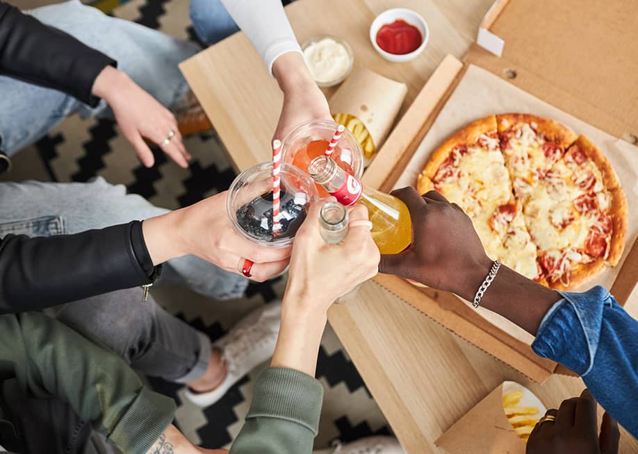 People raising their glass beverages while celebrating at home. — SeventyFour // Shutterstock