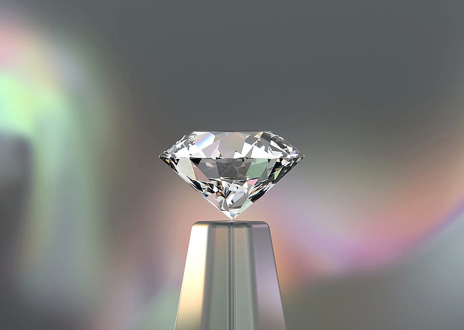 A 3D rendering of a round diamond with an iridescent backdrop. — Sararwut Jaimassiri // Shutterstock