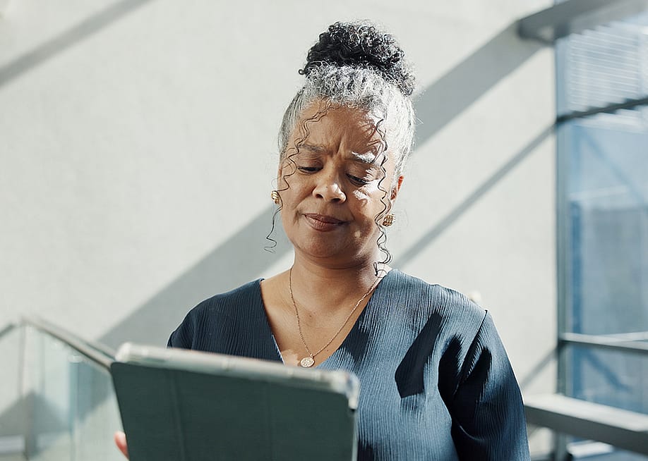 A female HR professional looking confused while reading information from a tablet. — PeopleImages // Shutterstock