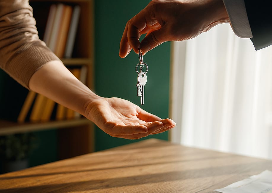 A new homeowner receives keys from real estate agent. — Yuganov Konstantin // Shutterstock