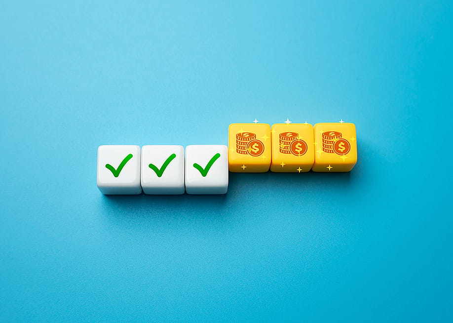 A die set with half showing a green check symbol and the other half are coin icons as a concept of incentive strategy. — Andrii Yalanskyi // Shutterstock